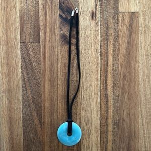 Blue/teal stone on a velvet black choker.